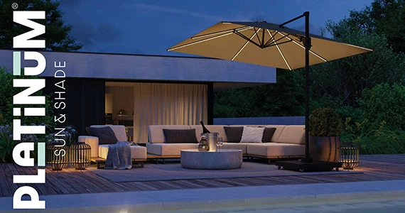 Sonnenschirm T2 Glow mit LED Beleuchtung steht neben einem Pool am Abend